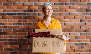 mujer-mayor-sosteniendo-caja-carton-articulos-para-donar